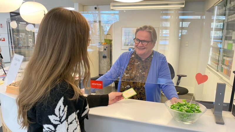 Salon liikennepalveluiden kuljetuskoordinaattori asioimassa Salon kaupungintalon infopisteessä infopisteen hoitajan kanssa.