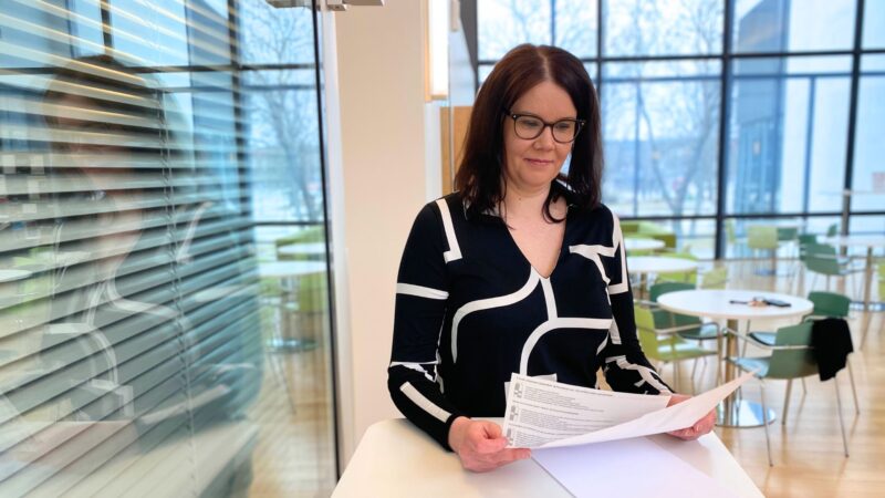 Salon kaupungin hankintapäällikkö Päivi Kohvakka lukemassa papereita pyödän ääressä Salon kaupungintalon yläaulassa. 