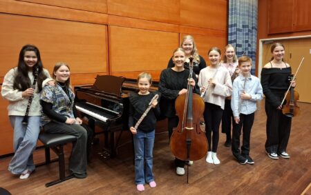 Kuvassa on musiikkiopiston nuoria soitinoppilaita soittimineen: klarinetisti, pianisti kolme huilistia, sellisti ja kolme viulistia.