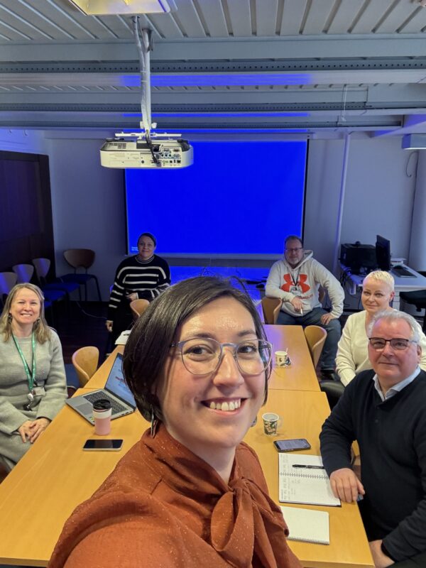 Yrittäjäyhdistysten ja Salon kaupungin edustajat kokouksessa. Henkilöitä on yhteensä kuusi istumassa ison pöydän äärellä. Kaikki hymyilevät ja katsovat kameraan.