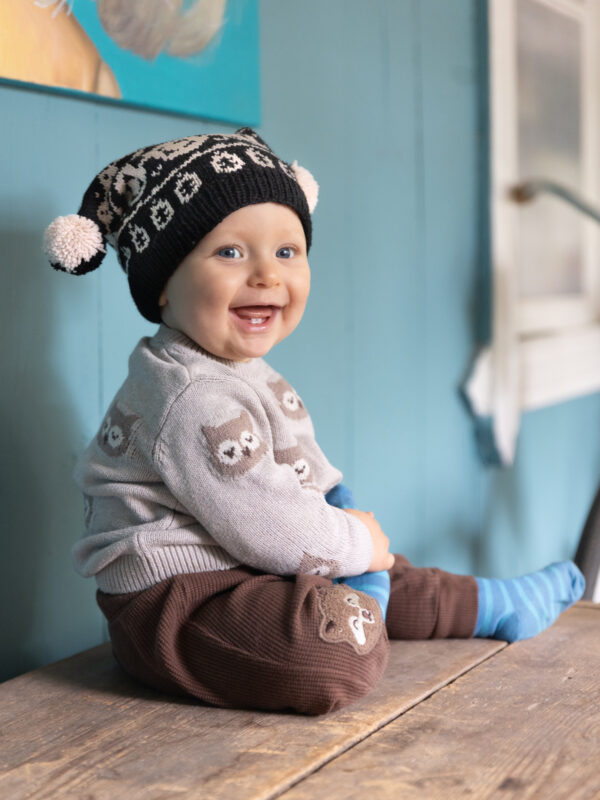 Nauravainen taapero villapipo pääsään.